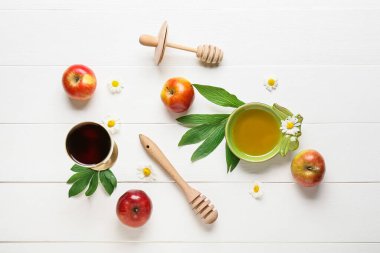 Elmalı bal ve beyaz ahşap arka planda kutsal şarap kadehi. Rosh hashanah (Yahudi Yeni Yılı) kutlaması