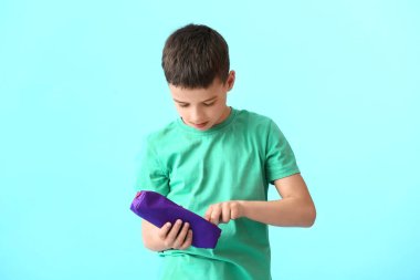 Renkli arka planda kalem kutusu olan küçük çocuk.