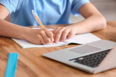 Küçük çocuk evde online çalışıyor.