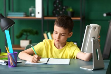 Küçük çocuk evde online çalışıyor.