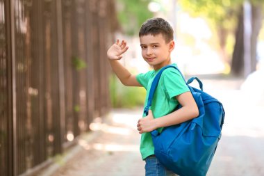 Sırt çantalı küçük okul çocuğu.
