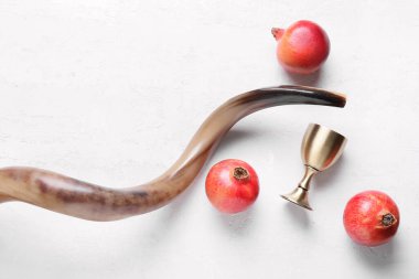 Beyaz arka planda şarap ve nar için kutsal kadehlerle Shofar. Rosh hashanah (Yahudi Yeni Yılı) kutlaması