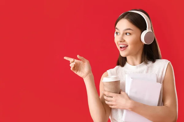 Mujer Joven Con Libro Taza Café Auriculares Que Muestran Algo —  Fotos de Stock