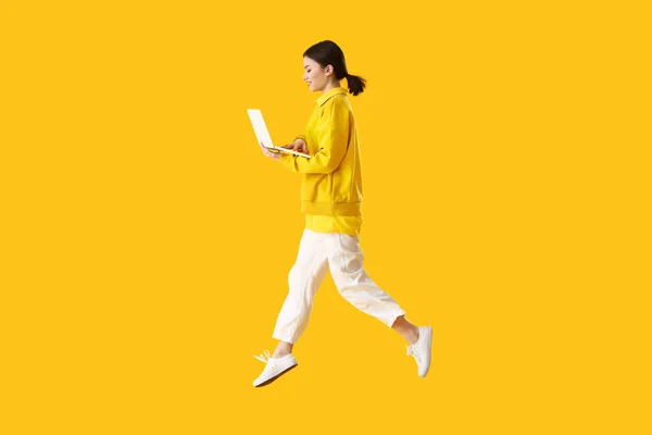 Springen Jonge Vrouw Met Laptop Kleur Achtergrond — Stockfoto