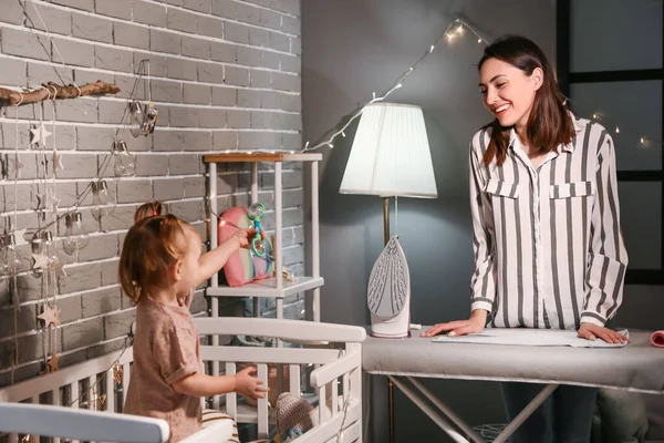 Mother Little Baby Ironing Clothes Home Late Evening — Stock Photo, Image