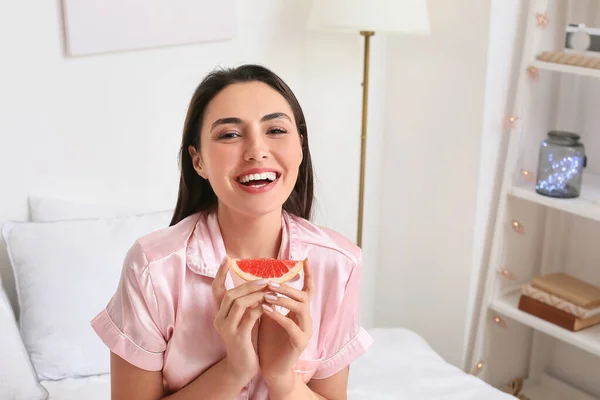 卧室里有多汁柚子的年轻女人 — 图库照片