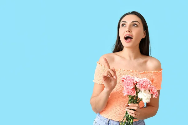 Mladá Žena Karafiáty Květiny Ukazuje Něco Barevném Pozadí — Stock fotografie