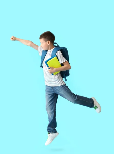 Kleine Schooljongen Met Notitieboekjes Springen Kleur Achtergrond — Stockfoto
