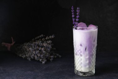 Koyu arkaplanda lavantalı bir bardak taze kokteyl.