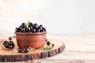 Tahta masada olgun siyah üzümlü kase.