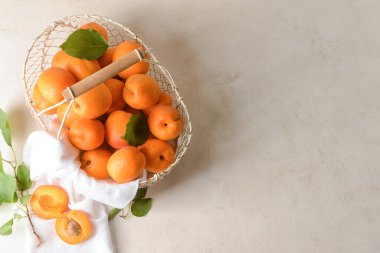 Hafif arka planda lezzetli olgun kayısılarla dolu sepet.