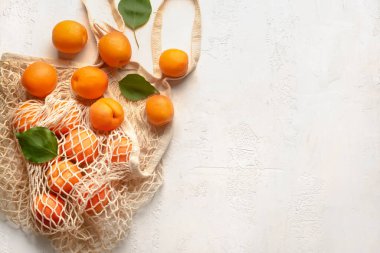 Hafif arka planda lezzetli olgun kayısılarla dolu bir çanta.