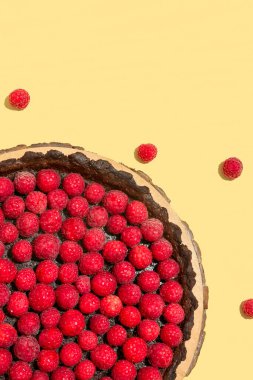 Renkli arkaplanda lezzetli ahududu turtası olan tahta