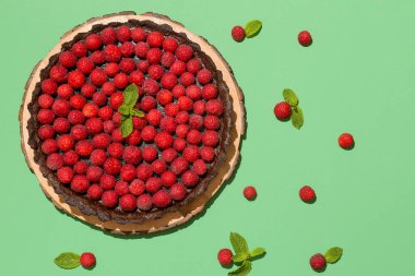 Lezzetli ahududu turtası ve renkli arkaplanda nane şekeri olan tahta