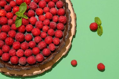 Lezzetli ahududu turtası ve renkli arkaplanda nane şekeri olan tahta