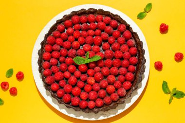 Lezzetli ahududu turtası ve renkli arkaplanda nane şekeri olan tahta