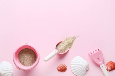 Çocuklar için plaj aksesuarları, renkli arka planda kum ve deniz kabukları