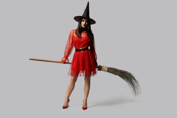 美しい女性は 明るい背景に魔女としてハロウィーンの服を着てください — ストック写真