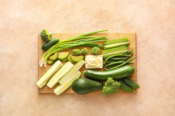 Доска Различными Зелеными Овощами Миска Соусом Цветном Фоне — стоковое фото
