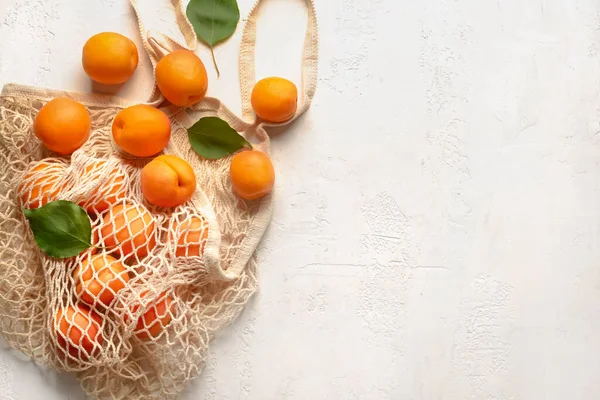 Hafif arka planda lezzetli olgun kayısılarla dolu bir çanta.