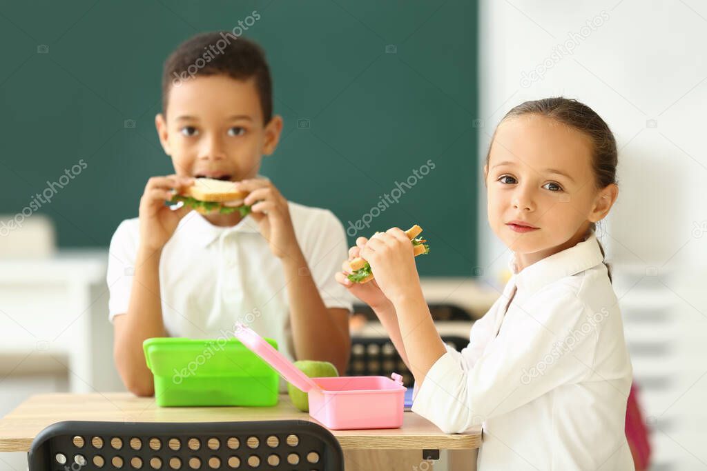 Cute little children having lunch at school
