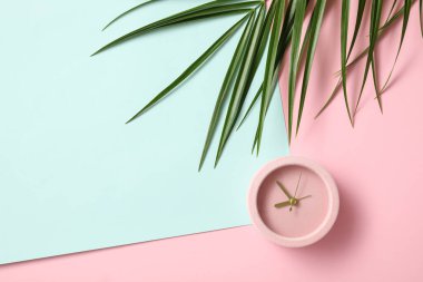 Renk arkaplanında tropikal yaprak olan alarm saati