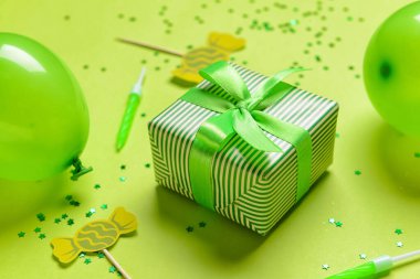 Arkaplanda hediye kutusu, balonlar, mumlar ve konfeti, yakın plan.