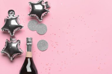 Bir şişe şampanya, balonlar ve renkli konfeti.