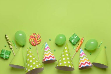 Parti şapkaları, hediye kutuları, balonlar ve renkli arka planda şekerler