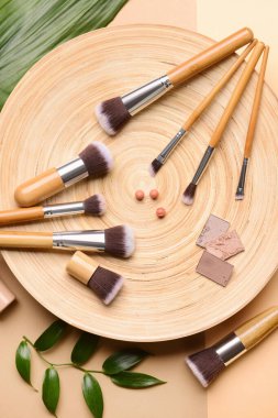 Dekoratif makyaj malzemeleriyle renk arkaplanı üzerine makyaj fırçaları