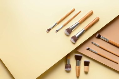 Renk arkaplanındaki makyaj fırçaları