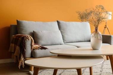 Oturma odasındaki masada çiçekli vazo.