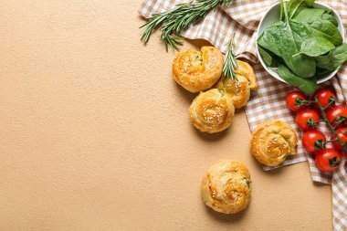 Arka planda ıspanak ve sebzelerle doldurulmuş puf böreği.