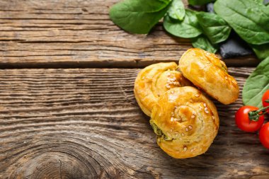 Tahta arka planda ıspanakla doldurulmuş puf böreği.