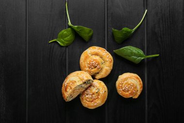 Koyu ahşap arka planda ıspanakla doldurulmuş puf böreği