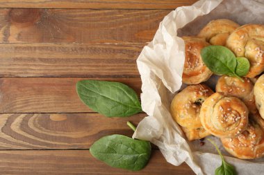 Tahta arka planda ıspanakla doldurulmuş puf böreği.