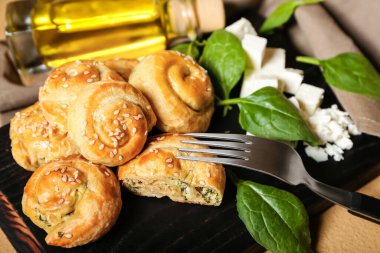 Arkaplanda ıspanak ve peynir ile doldurulmuş puf böreği.