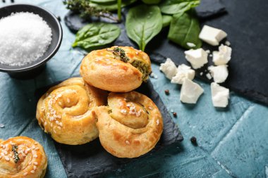 Arkaplanda ıspanak ve peynir ile doldurulmuş puf böreği.