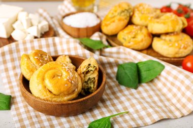 Hafif arka planda ıspanakla doldurulmuş puf böreği.