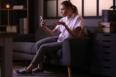 Akşam geç saatlerde evde video sohbeti yapan genç bir kadın.