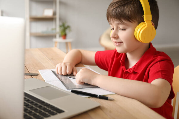 Little boy studying online at home