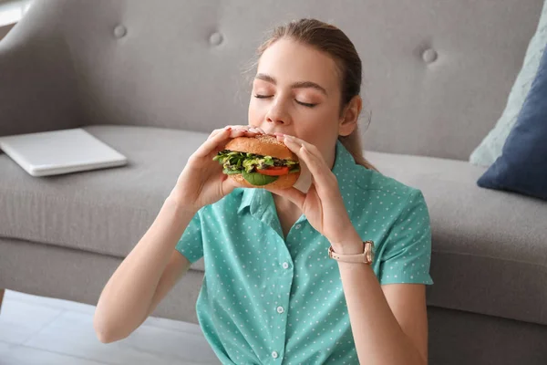 Young Woman Eating Tasty Vegan Burger Home — Stock Photo, Image