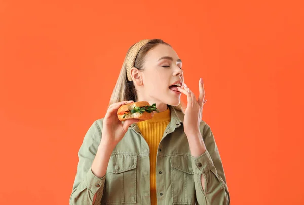 Young Woman Eating Tasty Vegan Burger Color Background — Stock Photo, Image