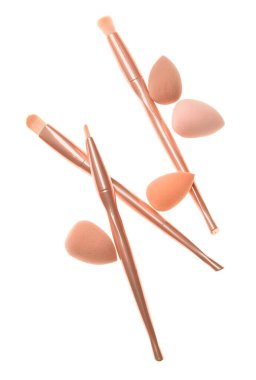 Beyaz arkaplanda kozmetik süngerler ve fırçalar