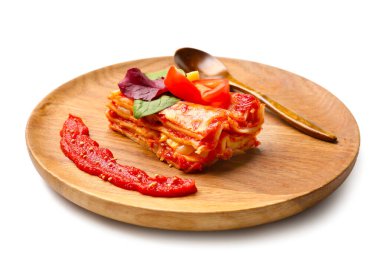 Beyaz arka planda bir parça lezzetli domates lazanyası.