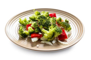 Beyaz zemin üzerinde brokoli olan lezzetli bir salata tabağı.