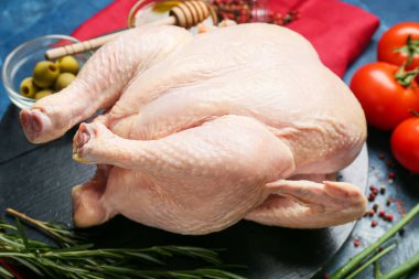 Renkli arka planda çiğ tavuk ve baharat olan pano, yakın plan.