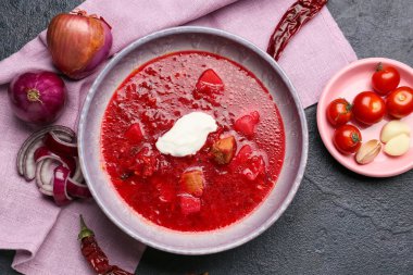 Koyu arkaplanda ekşi kremalı ve sebzeli bir kase lezzetli çorba.