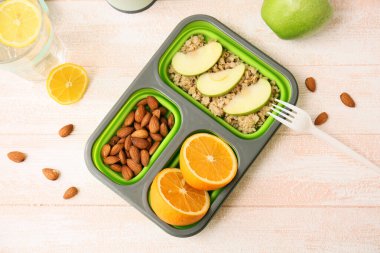 Hafif ahşap arka planda lezzetli yiyeceklerin olduğu beslenme çantası.