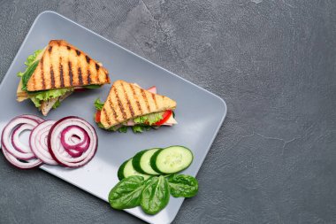 Koyu arka planda lezzetli sandviçler ile Plaka